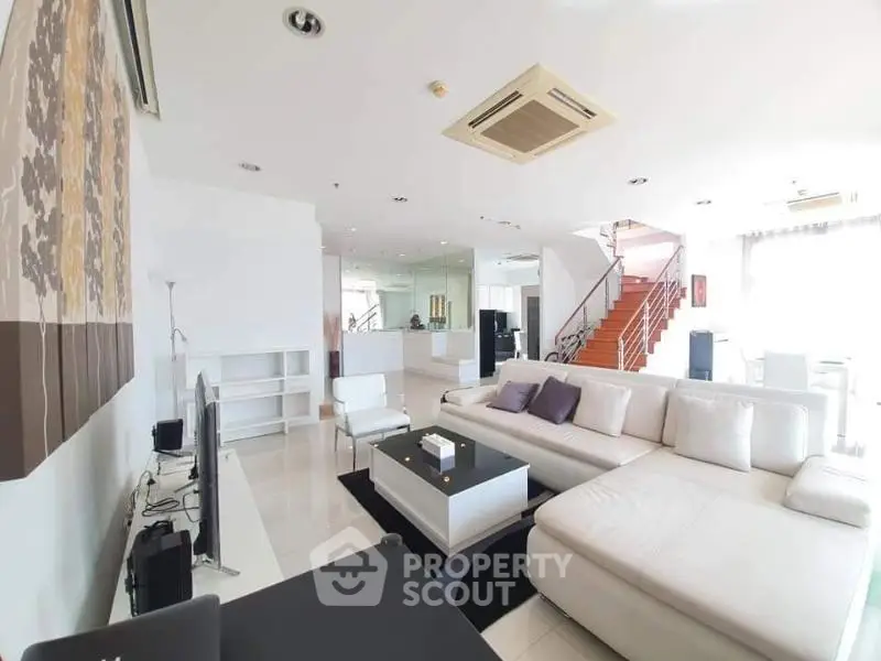 Spacious modern living room with white sectional sofa and sleek decor