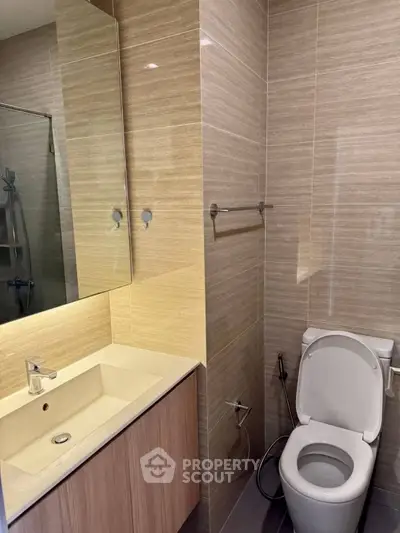 Modern bathroom with sleek fixtures and elegant design, featuring a spacious vanity and contemporary toilet.