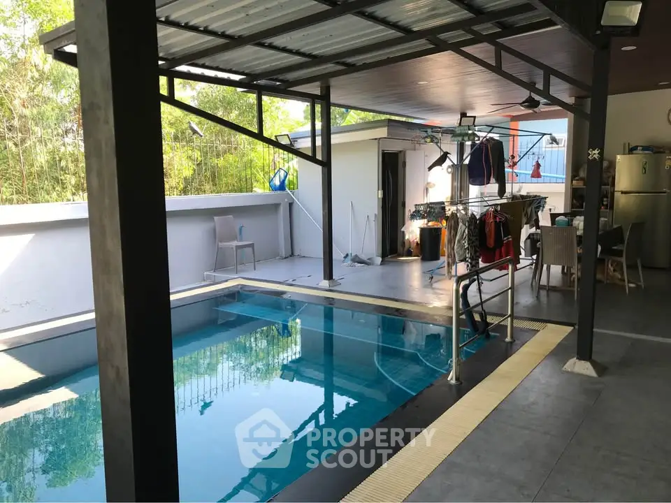 Modern home with covered pool area and outdoor seating, perfect for relaxation and entertainment.