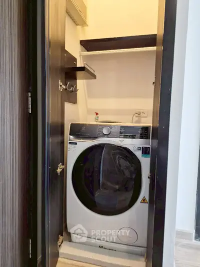 Compact laundry area with modern washing machine in a sleek cabinet