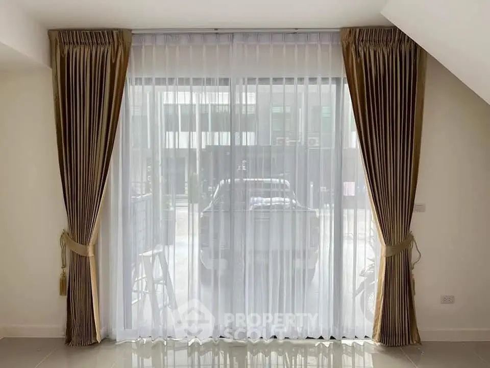 Elegant living room with floor-to-ceiling windows and luxurious curtains.