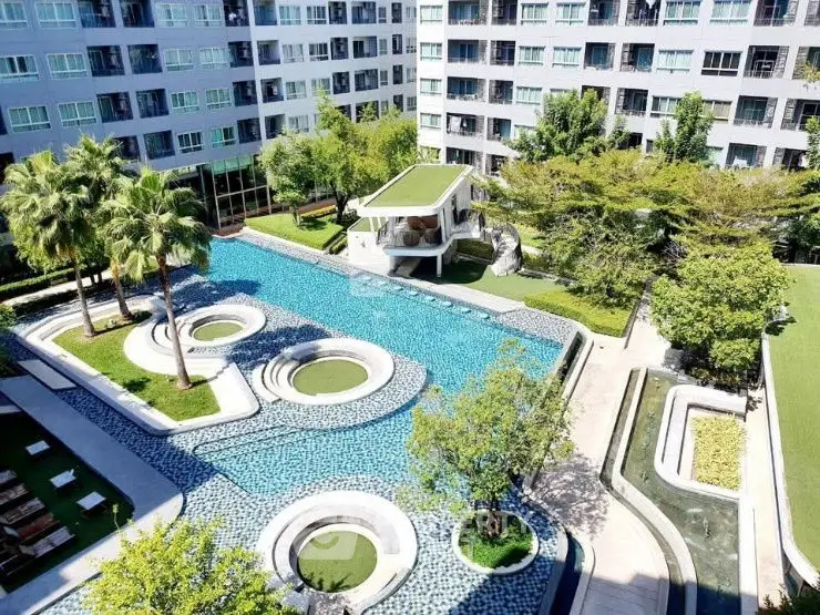 Luxurious apartment complex with stunning pool and lush greenery