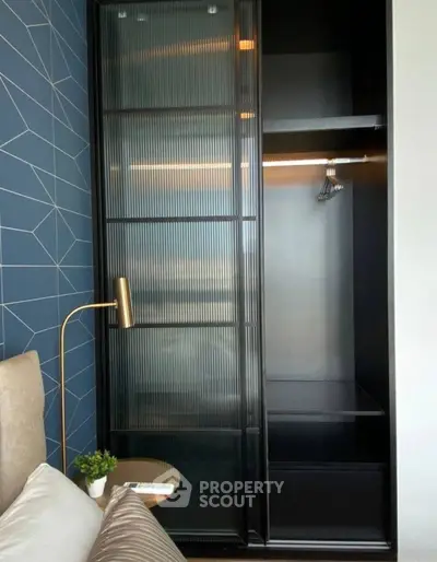 Modern bedroom with sleek black wardrobe and geometric accent wall