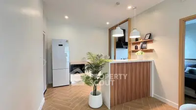 Modern kitchen with sleek design, featuring white appliances and stylish lighting.