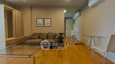Spacious living room with modern furniture and wooden flooring in a stylish apartment.