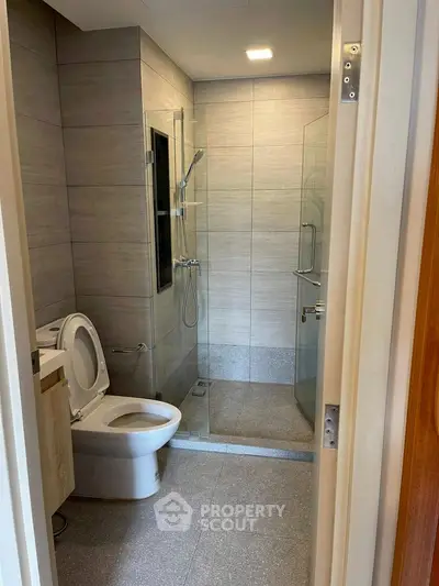 Modern bathroom with sleek shower and toilet in contemporary design.