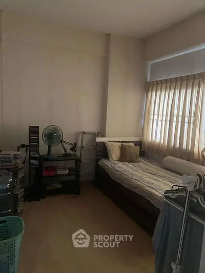 Cozy bedroom with natural light and simple furnishings, ideal for a peaceful retreat.
