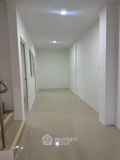 Spacious hallway with modern tile flooring and bright lighting, ideal for versatile use in a contemporary home.