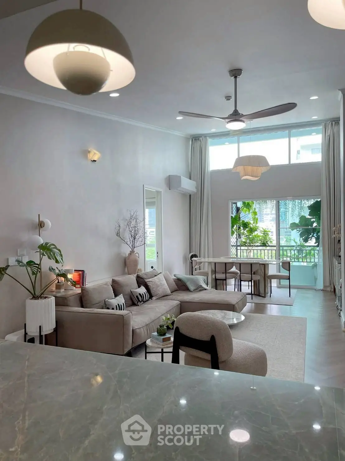 Spacious modern living room with elegant decor and large windows offering natural light.