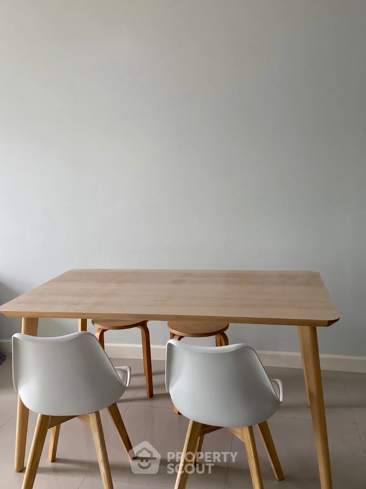 Modern minimalist dining area with wooden table and white chairs