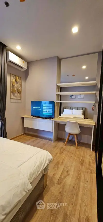 Modern bedroom with stylish decor and built-in desk, featuring a cozy bed and elegant lighting.