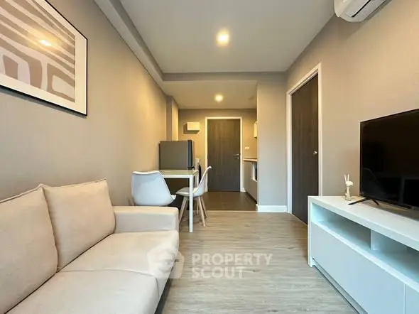Modern living room with cozy beige sofa and sleek TV unit in a stylish apartment.