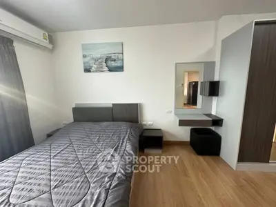 Modern bedroom with stylish decor and natural light, featuring a cozy bed and sleek furniture.