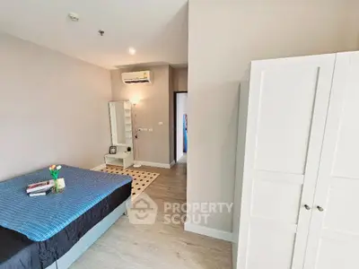 Spacious bedroom with modern decor and ample natural light, featuring a cozy bed and stylish wardrobe.