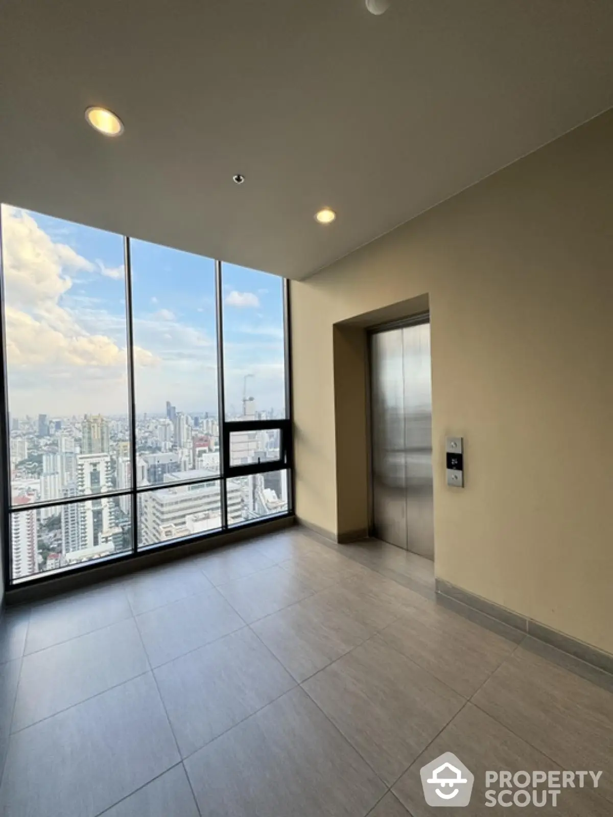 Modern high-rise elevator lobby with stunning city view through large windows.