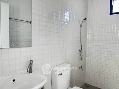 Modern minimalist bathroom with white tiles and sleek fixtures