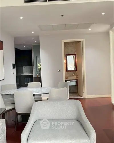 Modern living area with elegant dining set and view into a stylish bathroom