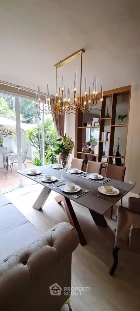 Elegant dining room with modern chandelier and garden view