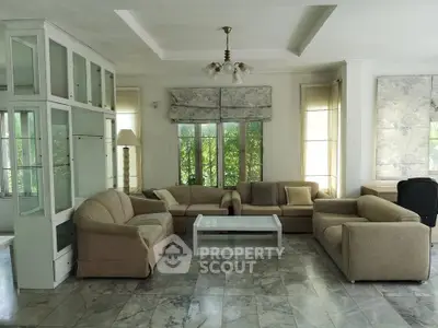 Spacious living room with elegant sofas and large windows offering natural light.