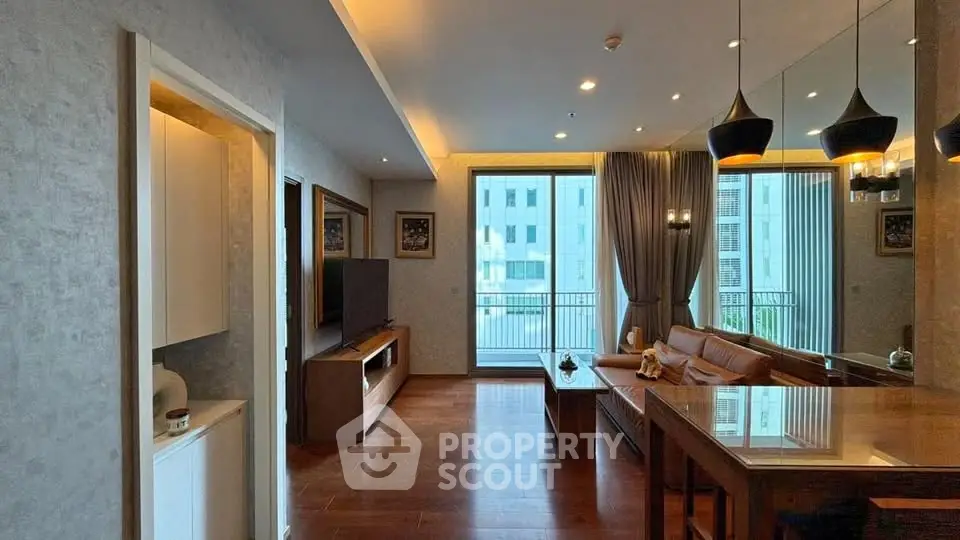Modern living room with elegant decor and large windows offering natural light and city views.