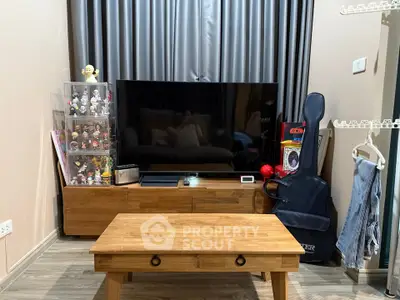 Cozy living room with modern TV setup and stylish wooden furniture.