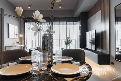 Elegant dining area seamlessly connects to a modern living space with stylish decor and abundant natural light, perfect for urban living.