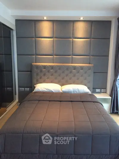 Luxurious bedroom with elegant padded wall and modern lighting
