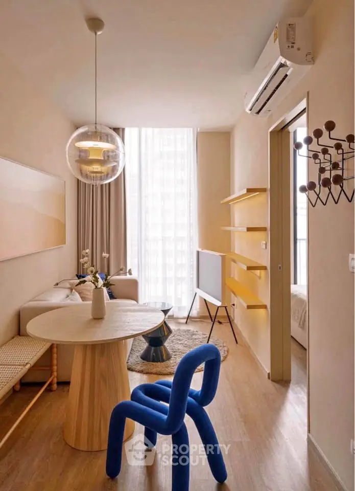 Stylish modern living room with unique blue chair and natural light