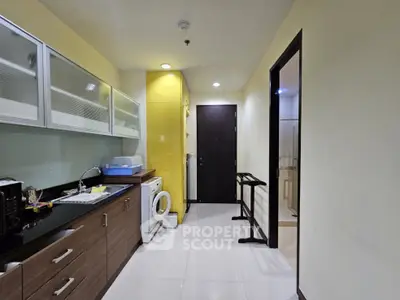 Modern kitchen with sleek cabinets and washing machine in a compact layout