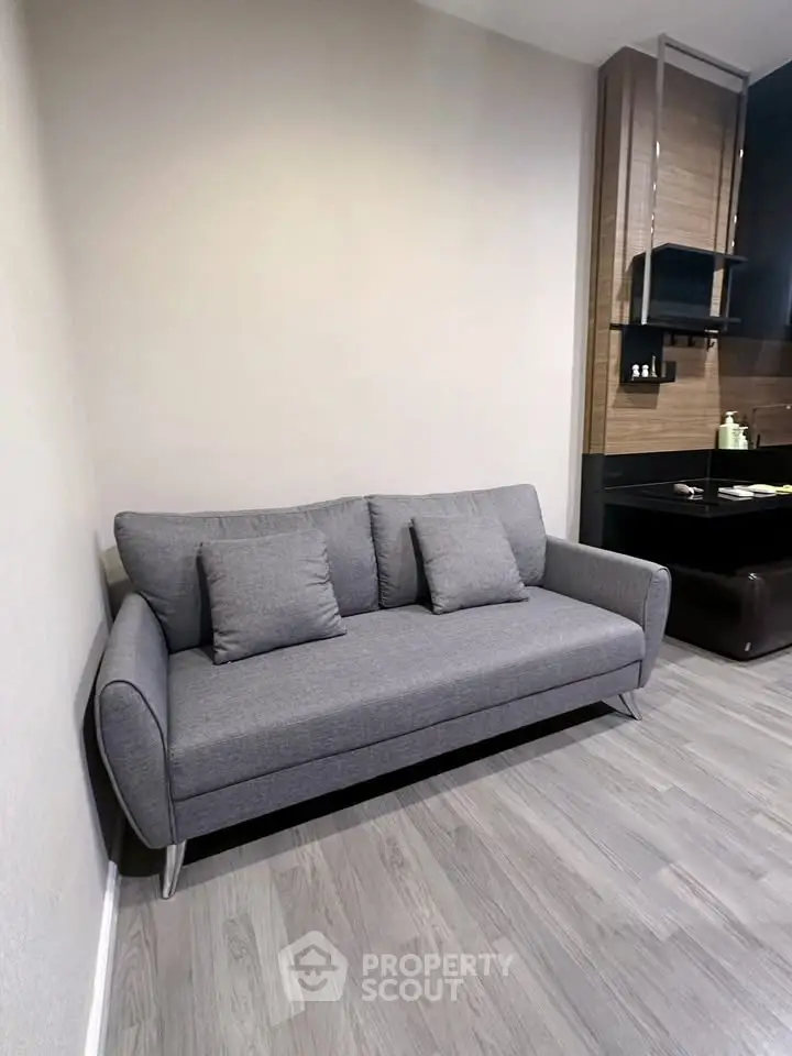 Modern living room with stylish gray sofa and sleek wooden accents.