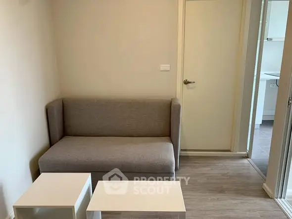 Cozy small living room with modern gray sofa and white tables