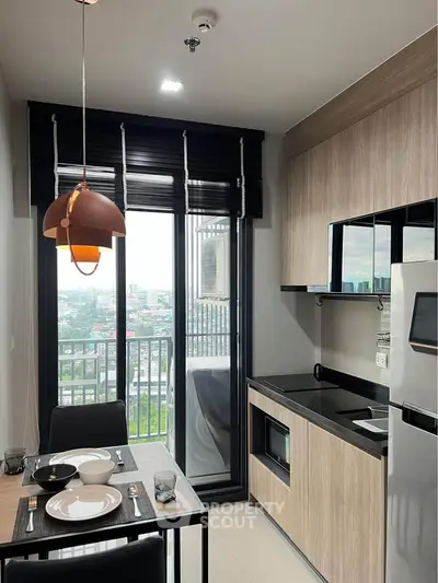 Modern kitchen with sleek cabinetry and balcony view in urban apartment