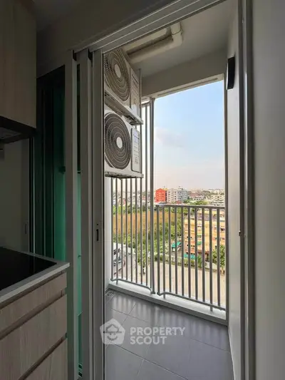Modern apartment balcony with city view and air conditioning units, perfect for urban living.