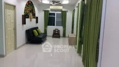 Spacious living room with modern decor and green accents