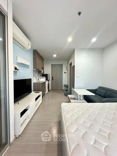 Modern studio apartment with open layout, featuring a cozy living area, compact kitchen, and stylish furnishings.