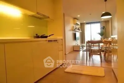Modern open-layout kitchen and dining area with stylish lighting and cozy ambiance.