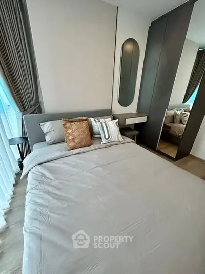 Modern bedroom with stylish decor and large mirror wardrobe