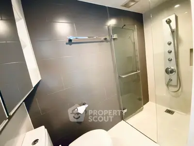 Modern bathroom with sleek glass shower and dark tile accents