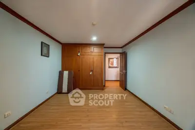 Spacious empty room with wooden flooring and built-in wardrobe