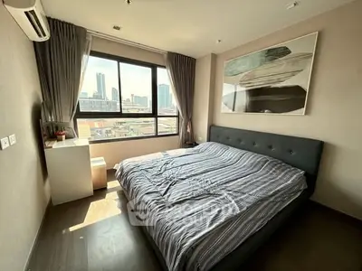 Modern bedroom with city view, featuring stylish decor and ample natural light.