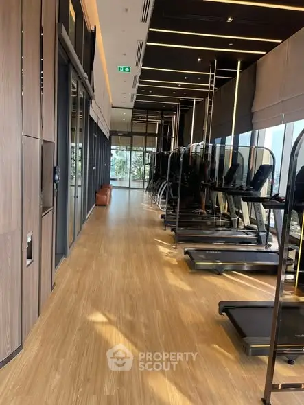 Modern gym with sleek treadmills and wooden flooring in luxury building