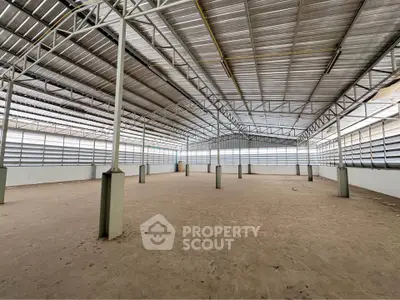 Spacious industrial warehouse with high ceilings and ample natural light, perfect for storage or manufacturing.