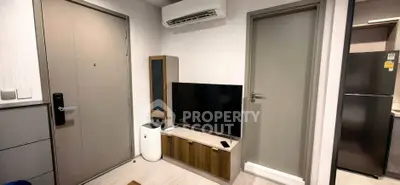 Modern living room with sleek TV setup and air conditioning in a cozy apartment.