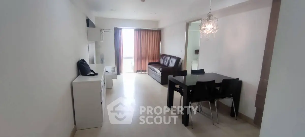 Spacious living room with modern furniture and elegant chandelier in a bright apartment.