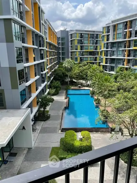 Modern apartment complex with pool and lush greenery, perfect for urban living.