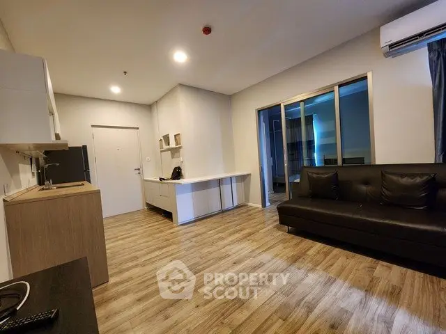 Spacious modern living room with sleek wooden flooring and stylish furnishings.