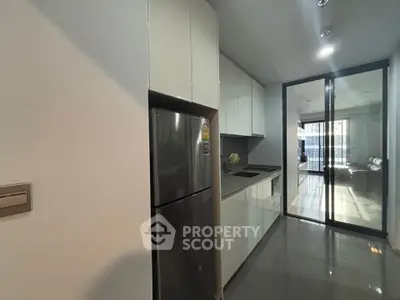 Modern kitchen with sleek cabinetry and stainless steel appliances in a contemporary apartment.
