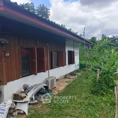Charming rustic house with lush garden and wooden exterior, perfect for nature lovers.