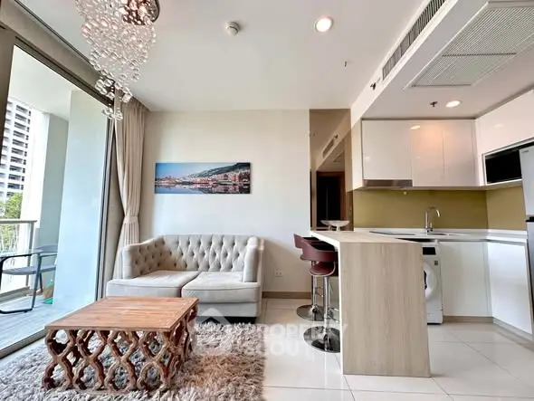 Modern open-layout living room with chic decor and balcony view in luxury apartment.