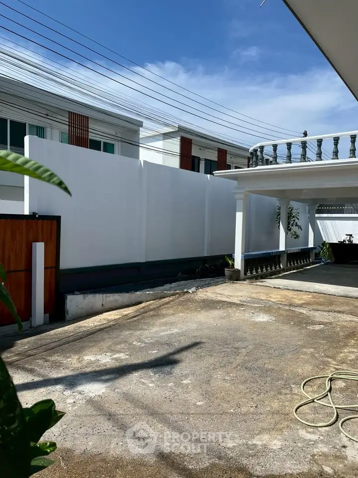 Spacious residential driveway with modern architecture and clear blue sky.